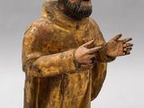 an old wooden statue of a man with a beard and a robe