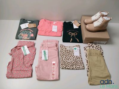 Plusieurs paires de pantalons roses et une paire de chaussures blanches sont posées sur une table.