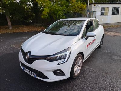 une voiture blanche garée sur le bord de la route, devant une maison