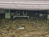 a pile of rocks under a building with a bench in the middle of it