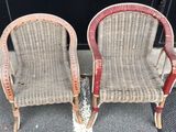 two wicker chairs sitting next to each other on the sidewalk