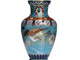 a blue vase with a bird on it on a white surface