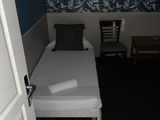 un petit lit dans une petite chambre avec du papier peint bleu