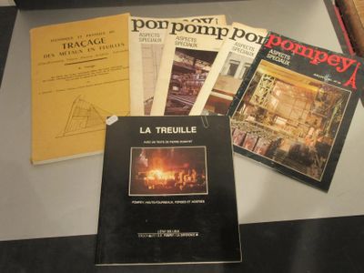 Plusieurs livres sont posés sur une table devant un ordinateur portable