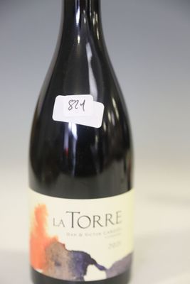 a bottle of wine sitting on top of a table next to a bottle of wine