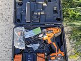 an orange and black tool kit sitting on the ground next to some grass