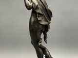 a bronze statue of a man holding a dog on a rock