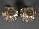 pair of silver plated earrings with pearls on a black surface