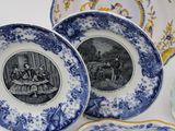 several blue and white plates with pictures of people on them