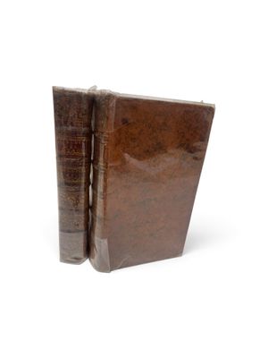 un livre marron ouvert sur une surface blanche