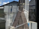 a truck that is parked next to a building with a ladder