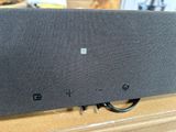 une enceinte noire posée sur une table en bois