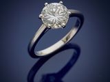 a single stone diamond ring on a blue background