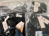 four pairs of black shirts in plastic bags on a table
