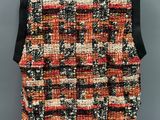 a black and orange tweed vest with black leather shoulders