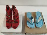 pair of red and blue sandals in a box on a bed