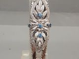 un gros plan d'une bague en argent sertie de pierres bleues et blanches