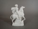 a white figurine of a man riding a horse