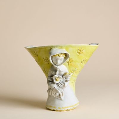 un petit vase dans lequel figure une femme tenant une fleur