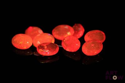 several pieces of red fire oplite sit on a black surface
