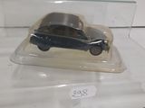 a small toy car in a glass case on a table