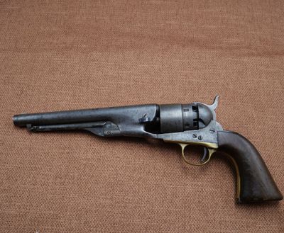 an old revolver with a wooden handle on a brown background