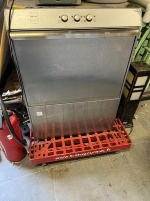 a silver dishwasher sitting on a red rack in a garage