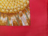 a red pillow with a picture of a sunflower on it