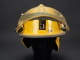 yellow fireman ' s helmet on display against a black background