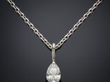 un pendentif en diamant suspendu à une chaîne sur fond noir