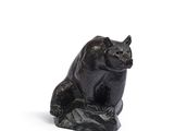 statue d'un chat noir assis sur un rocher, sur fond blanc