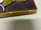two white flowers on a black and gold plate