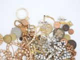 a pile of assorted jewelry on a white surface