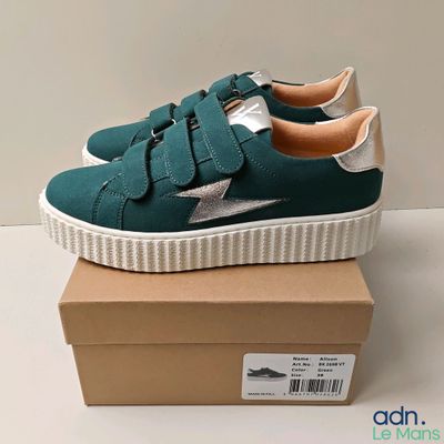 a close up of a pair of green sneakers on a box
