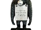statue d'un gorille tenant une pancarte sur laquelle est inscrit « »