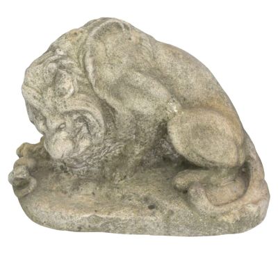 une statue représentant un chien couché sur un rocher
