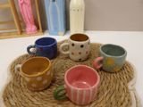 many cups sitting on a rope mat on a table