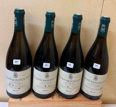 four bottles of wine are lined up on a wooden tray