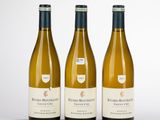 trois bouteilles de vin blanc posées sur une table