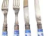 three forks and a knife are sitting next to each other on a white surface