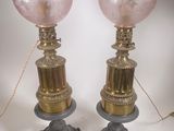 paire de lampes de table en verre rose sur des pieds en fonte