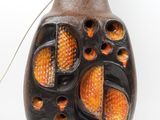 a brown vase with orange and black designs on it