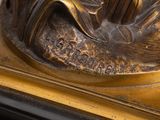 a bronze statue of a woman sitting on a bench