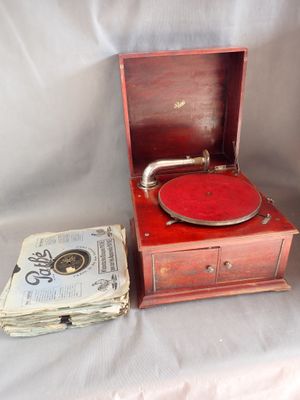 un vieux tourne-disque et une pile de journaux posés sur une table