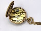 an image of a gold pocket watch with a chain on a white surface