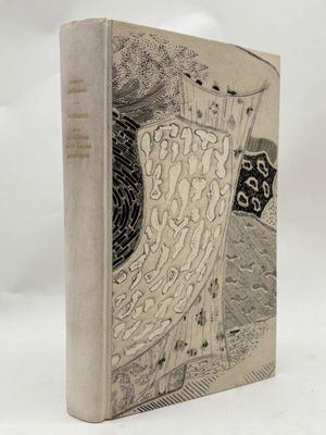 un vieux livre posé sur une table blanche à côté d'un mur blanc