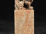 une figurine chinoise sculptée représentant un chien et un oiseau, sur un bloc de marbre