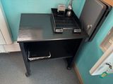 a small table with a laptop and a coffee maker on it