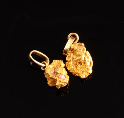 a pair of gold nuggies on a black surface