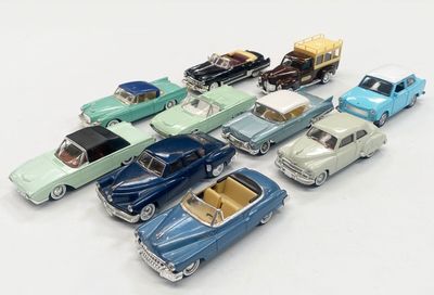 several toy cars are lined up in a row on a white surface
